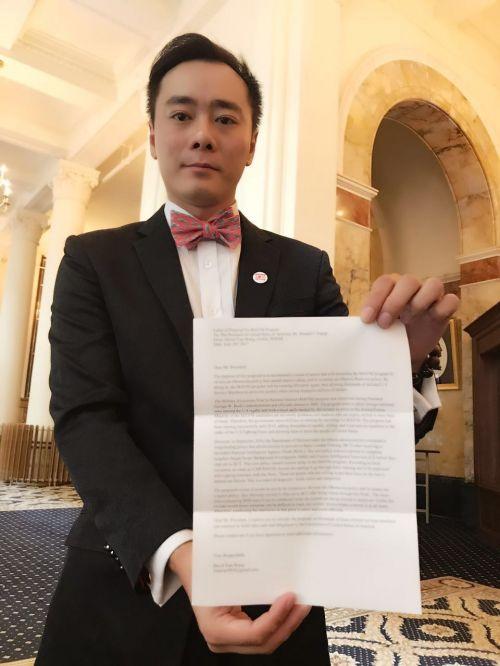 中国侨网王湉手中展示的是代表2000名华裔诉求的请愿信。(美国《侨报》/王湉提供)