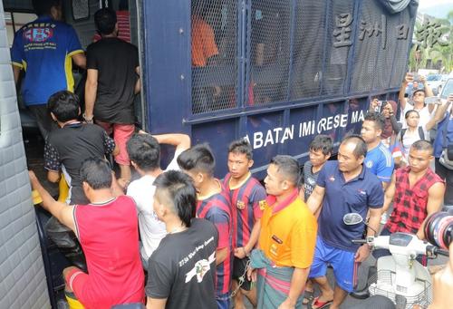 中国侨网违法的外劳被押上大卡车，载到移民局办事处。（马来西亚《星洲日报》）