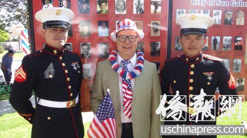 中国侨网廖钦和(中)和华裔海军士兵邓艾瑞(音译：Eric Deng)在退伍老兵图片墙前合影。（美国《侨报》/高睿 摄）