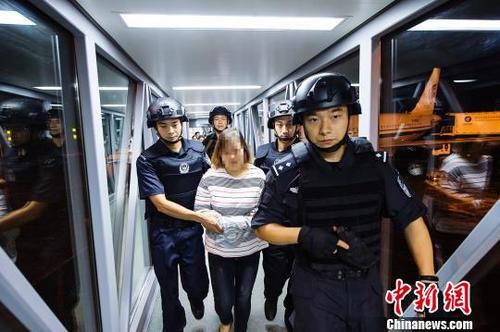 中国侨网胡某霞被押解途中。杭州警方供图