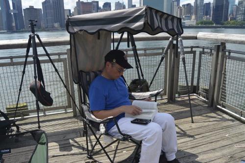 中国侨网Brian张带了一把沙滩防晒椅，坐在栈桥最前端看着书等待烟火。（美国《世界日报》/俞姝含 摄）