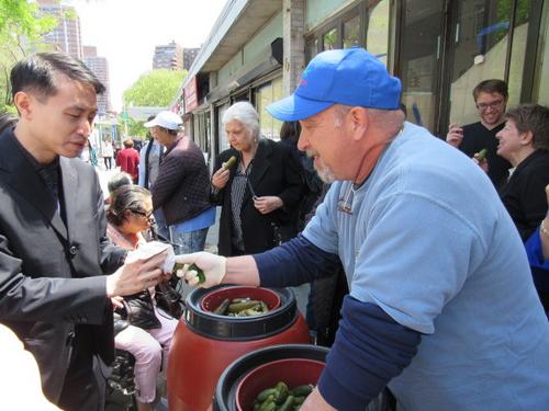中国侨网图为高夫曼与社区居民分享店内腌黄瓜等商品。(美国《世界日报》/颜嘉莹 摄)