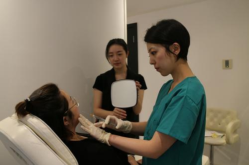 中国侨网Ai Beauty的整形医生Dr. Lau（右一）正在给病人注射。（法国《欧洲时报》/季欧哲 摄）