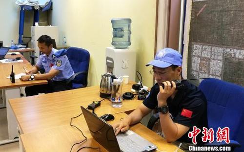 中国侨网图为：两位中国维和警察在指挥中心协调防爆队设卡（左为韦益毅）。浙江省公安厅供图