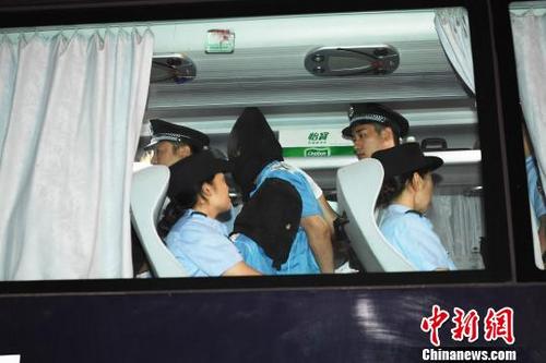 中国侨网犯罪嫌疑人在押解车上。 安源 摄