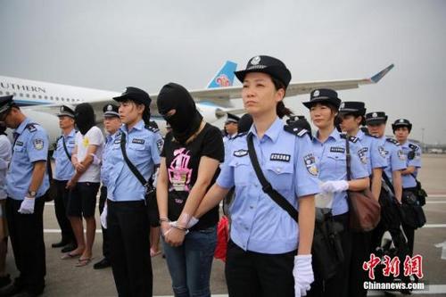 中国侨网资料图:广东警方将129名电信诈骗嫌疑人押解回广州。 中新社记者 粤警方 摄