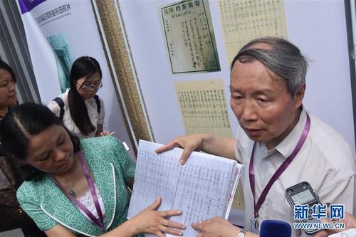 中国侨网资料图:中韩双方共同披露了一份载有135名“慰安妇”资料的名簿,即浙江省金华市档案馆馆藏《金华鸡林会会则及名簿》。图为中国“慰安妇”问题研究中心主任、上海师范大学教授苏智良(右一)与浙江省金华市档案局(馆)长陈艳艳(左下)介绍《金华鸡林会会则及名簿》档案发现的意义。新华社记者 蒋芳 摄