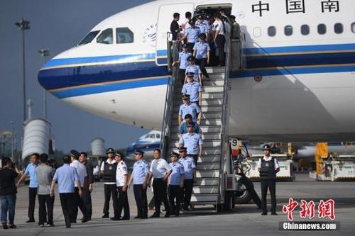 中国侨网8月5日，在长春龙嘉国际机场，77名电信诈骗犯罪嫌疑人从斐济押解回国。 张瑶 摄