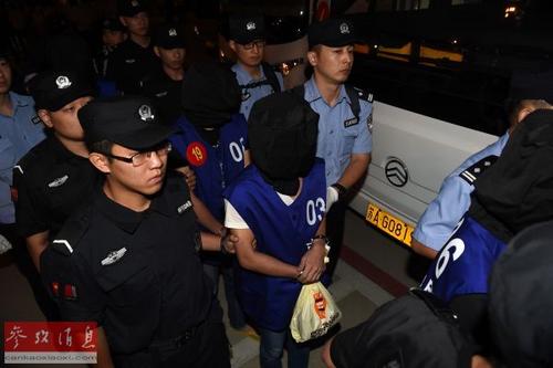 中国侨网资料图片：2016年9月20日，63名电信网络诈骗犯罪嫌疑人从柬埔寨被押解回国，警员押解犯罪嫌疑人准备登上大巴车。（新华社记者 韩瑜庆摄 ）