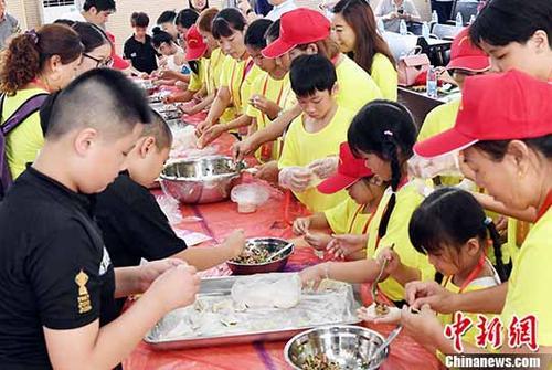中国侨网图为来自台湾的营员们与福清市百合小学师生一起包饺子。 中新社记者 刘可耕 摄