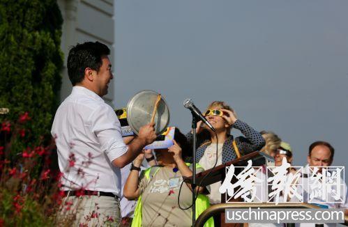 中国侨网洛杉矶市议员柳大为一边敲锅盖一边讲述中国有关日食的传说。(美国《侨报》/邱晨 摄)