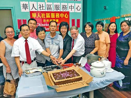 中国侨网刘文健双亲参加小区庆祝会一同切蛋糕。（美国《星岛日报》）