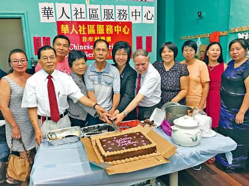 中国侨网刘文健双亲参加小区庆祝会一同切蛋糕。(美国《星岛日报》)