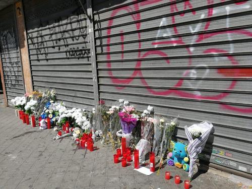 中国侨网事发店铺门口已经摆放了很多鲜花蜡烛悼念逝去的男孩。（西班牙欧浪网）