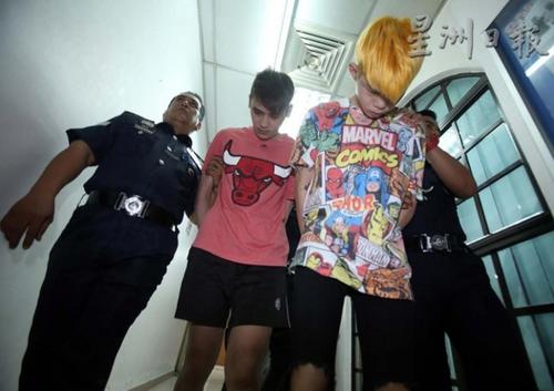 中国侨网染著金发的19岁被告梁忠兴,与20岁的冯凌舟,低着头被押致法庭面控,人名皆译音。(马来西亚《星洲日报》)
