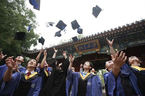 中国侨网资料图：北京大学的本科毕业生们身着学士服在校门旁留影。新华社记者 任正来 摄