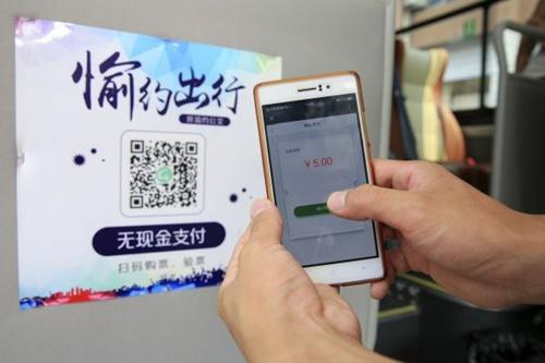中国侨网资料图片：8月3日，乘客在重庆市北碚区使用手机扫描二维码支付公交车费。