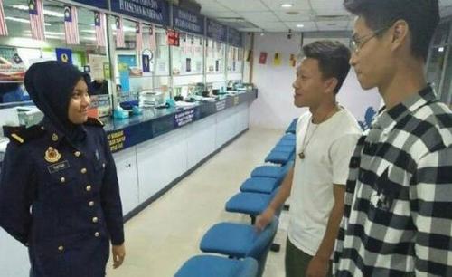 中国侨网图为努莎菲卡（左）以华语向两名山东留学生讲解如何办理车辆转名。（马来西亚《中国报》）