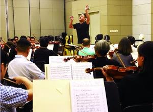 中国侨网国家大剧院排练厅内，吕嘉正在指挥全球华人乐团进行排练。