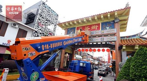 中国侨网工作人员安装牌匾时摄。(马来西亚《诗华日报》)