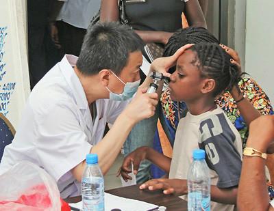 中国侨网国庆假期期间中国援刚果（布）医疗队员为布拉柴维尔居民进行义诊，送医送药。（《人民日报》图 李志伟摄）