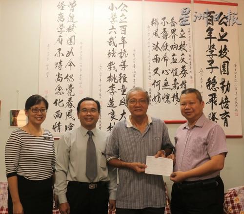中国侨网张凤芳的丈夫刘东南(右二)代表梁金耀移交10万令吉作为公立华小建校经费。左起是副校长李佳珈、校长余振荣及冯家声(右一)。(马来西亚《星洲日报》)