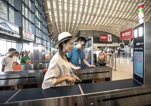中国侨网资料图:旅客通过脸部识别技术自助验证进站通道验票进站。 新华社记者 熊琦摄
