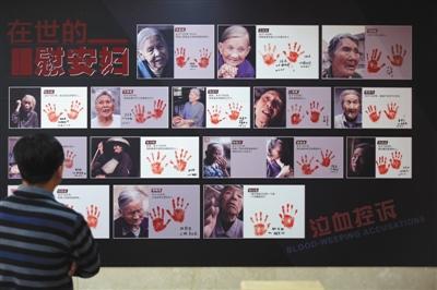 中国侨网2016年12月10日，中国人民抗日战争纪念馆，观众在观看纪实画册《90位幸存慰安妇实录》展示的书中照片。画册揭露“二战”时日军的反人类罪行。新京报记者 浦峰 摄