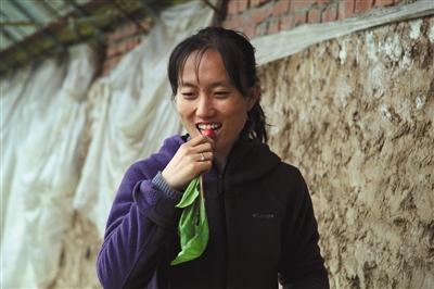 中国侨网石嫣品尝自己种植的蔬菜。 资料图片