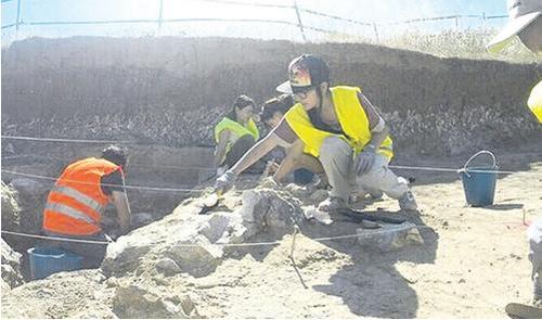 中国侨网图为赵晓娴(中)在西班牙马德里市郊区Los Ahijones 旧石器遗址进行挖掘。
