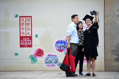 中国侨网资料图片：一位北京大学毕业生在毕业典礼前与家人自拍留念（2016年7月5日摄）。新华社记者鞠焕宗 摄