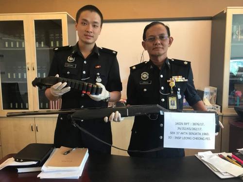 中国侨网阿尔萨（右起）及梁昌辉展示充公的枪支及子弹。（马来西亚《诗华日报》）