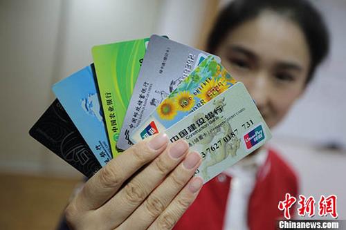 中国侨网图为一位南京市民展示她所拥有的不同银行的银行卡。(资料照片) 中新社记者 泱波 摄