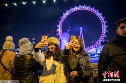 中国侨网资料图：当地时间2017年12月31日，民众聚集在在英国伦敦眼前迎接新年到来。
