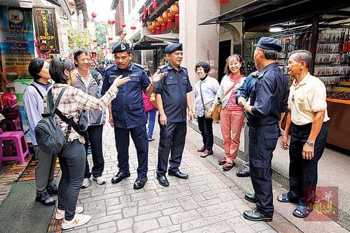 中国侨网阿都法达(左4)在二奶巷进行高调警政时与台湾游客交流。(马来西亚《光华日报》)