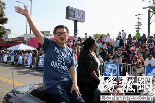 中国侨网加州州长华裔候选人江俊辉在游行队伍中向观众挥手致意。(美国《侨报》/邱晨 摄)