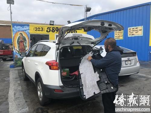 中国侨网修车厂工人正在为邓女士丰田车安装后玻璃。(美国《侨报》/高睿 摄)