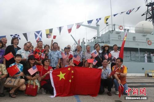 中国侨网资料图:当地时间2015年10月12日,中国海军郑和舰抵达美国夏威夷珍珠港,开始为期4天的友好访问。图为当地华侨华人在郑和舰前合影留念。 中新社记者 邓敏 摄