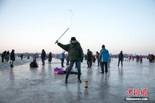 中国侨网资料图，游人在抽冰尜、拉耙犁、放烟花，尽情享受着冰雪的乐趣。中新社记者 于琨 摄