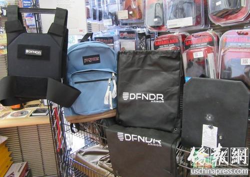 中国侨网亚凯迪亚市枪店内的防弹背心、可放置防弹板的背包,以及做过枪击实验的防弹板。(美国《侨报》/翁羽 摄)