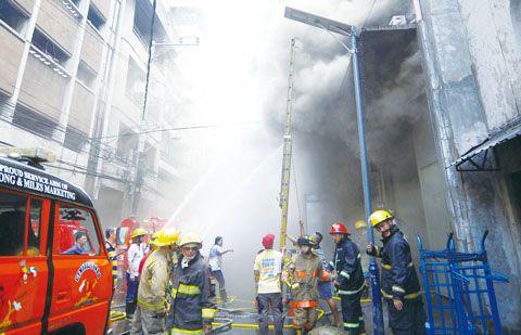 中国侨网马尼拉华人区伊干诺街一座仓库24日早晨发生火灾。图为消防员正全力救火。（《菲律宾商报》/记者Tony Ramos 摄）