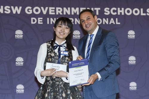 中国侨网毕云天（左）在迪斯达（右）手上接过“国际学生学术成就奖”的奖状和奖金。（澳大利亚《星岛日报》）