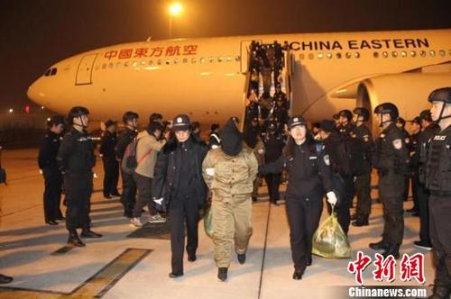 中国侨网民警将犯罪嫌疑人押解下飞机。警方供图