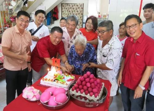 中国侨网老人张锦清（前排右三）切生日蛋糕，右是廖泰义，左起是郑国霖及倪可敏。（马来西亚《星洲日报》）