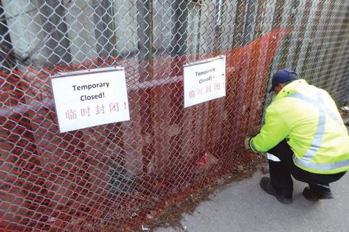 中国侨网市政工人用中英文写着“Temporary closed,临时封闭”。(加拿大《星岛日报》)