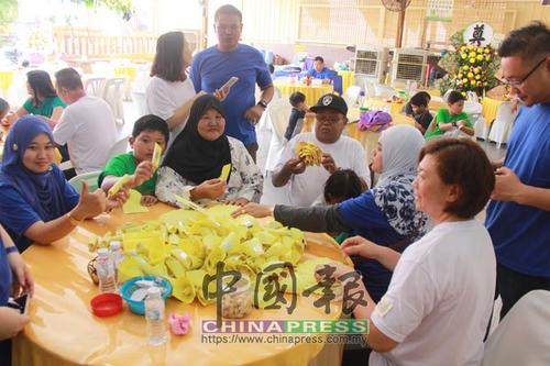 中国侨网玛西达(前左3起)和阿绍与子女和孙子们不避讳的穿上孝服,并在灵堂上折金纸。(马来西亚《中国报》)