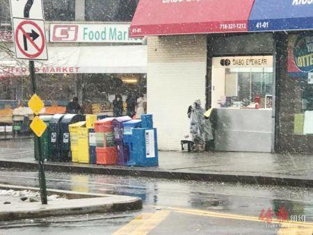 中国侨网发传单老妇风雪中继续工作。(美国《侨报》/王伊琳 摄)