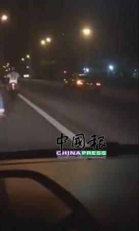 中国侨网失智老翁在北海外环公路反方向行驶，一位摩托司机跟随制止。（马来西亚《中国报》图片）