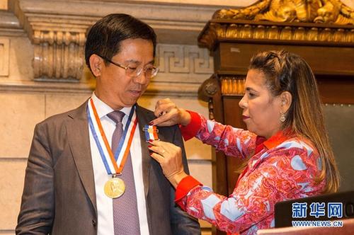 中国侨网里约市女议员塔尼亚·巴斯托斯为蔡鸿贤颁发勋章。新华网记者李明摄