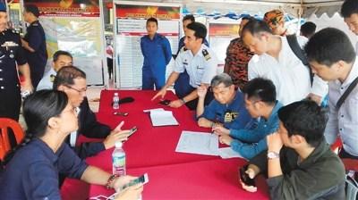 中国侨网 3月21日,一艘中国挖沙船在马来西亚附近海域倾覆。图为中国驻马来西亚大使馆人员在搜救现场与马方官员交流。 (照片由外交部领保中心提供)